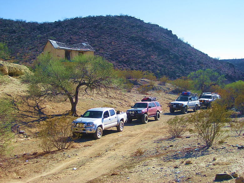 A car driving down a dirt road Description automatically generated