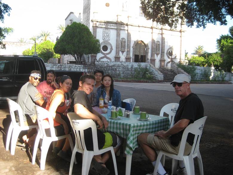 A group of people sitting on a bench Description automatically generated
