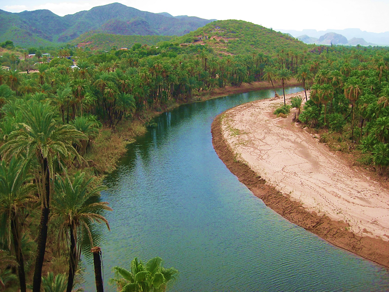 A body of water with a mountain in the background Description automatically generated