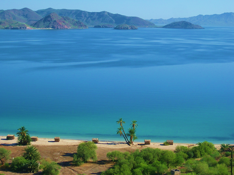 A large body of water with a mountain in the background Description automatically generated
