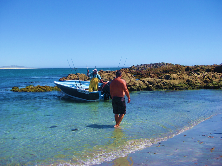 A person standing on a beach near a body of water Description automatically generated