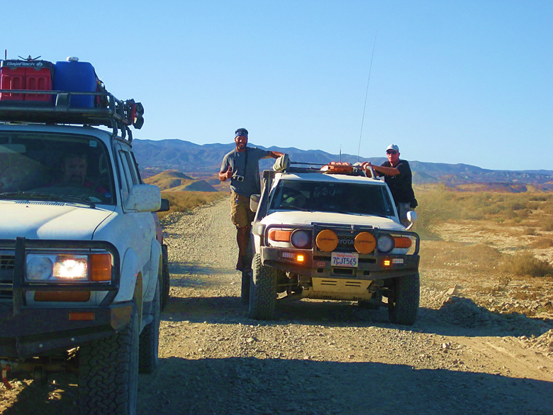 A truck driving down a dirt road Description automatically generated