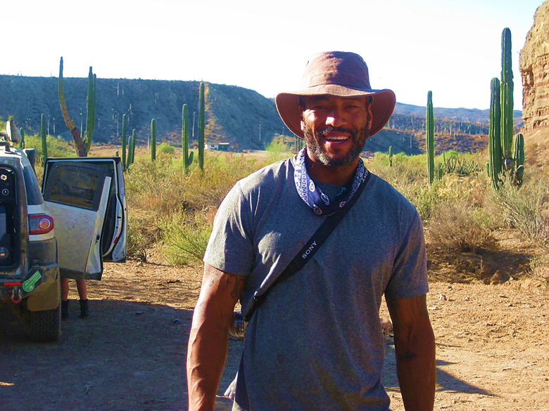 A person standing on a dirt road Description automatically generated